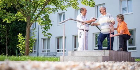 Arzt und Therapeutin mit einem Patienten