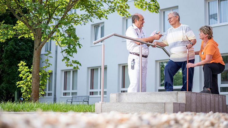 Arzt und Therapeutin mit einem Patienten