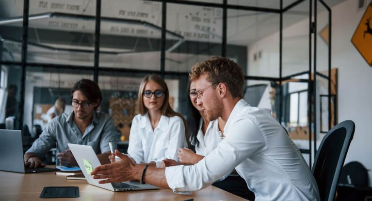 Junge Menschen sitzen zusammen im Büro und besprechen ein Projekt