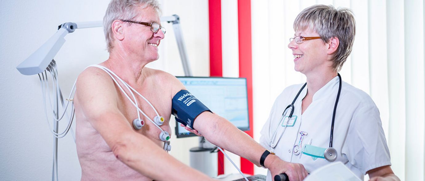 Pflegekraft überwacht Patient beim Belastungs-EKG