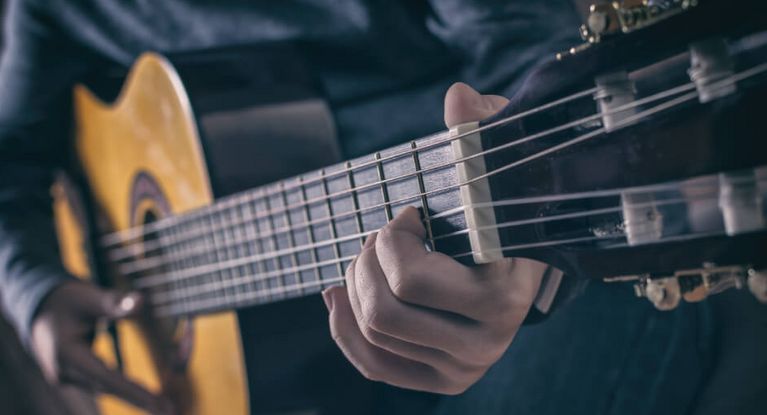 Mann spielt Gitarre auf einer Bühne